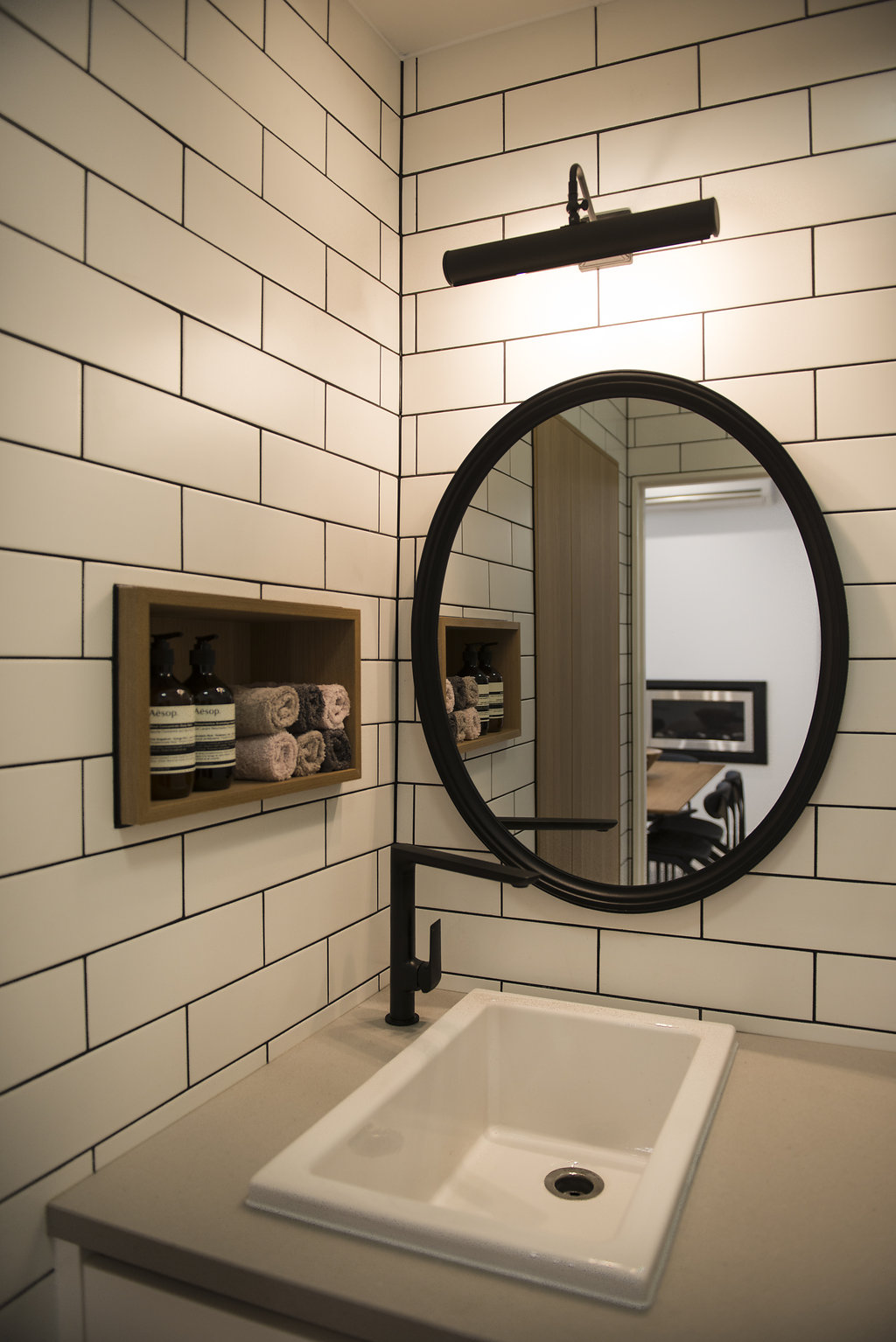 Laundry ideas Laundry renovations Carlton Subway tiles Contrasting grout Laundry design How to design a laundry Contemporary laundry ideas Caesar stone bench Laundry layout Black oval mirror Dark grout with white tiles