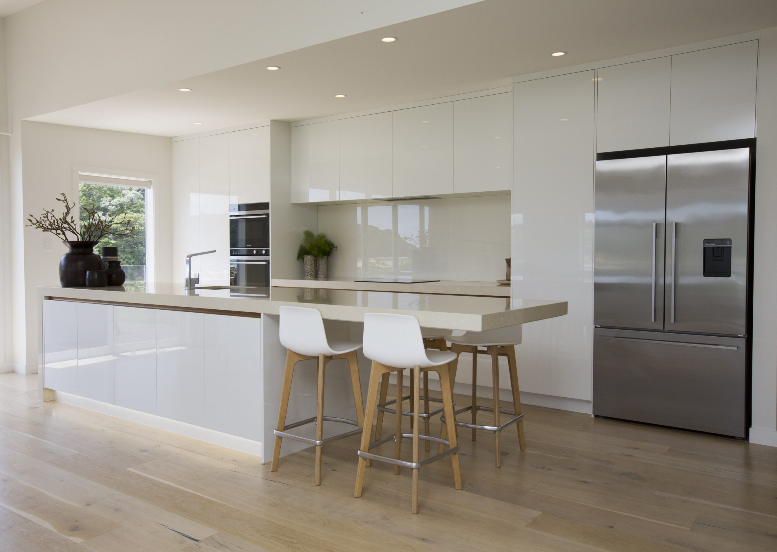 Bar stools, wall oven and island bench, a harmonious kitchen design by Natasha Walker Interiors at Sorrento Beach House, Melbourne